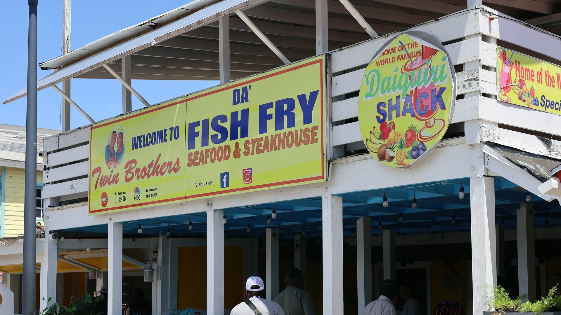 The Twin Brothers storefront on Arawak Cay, under the Welcome to Twin Brothers Fish Fry Seafood and Steakhouse sign.