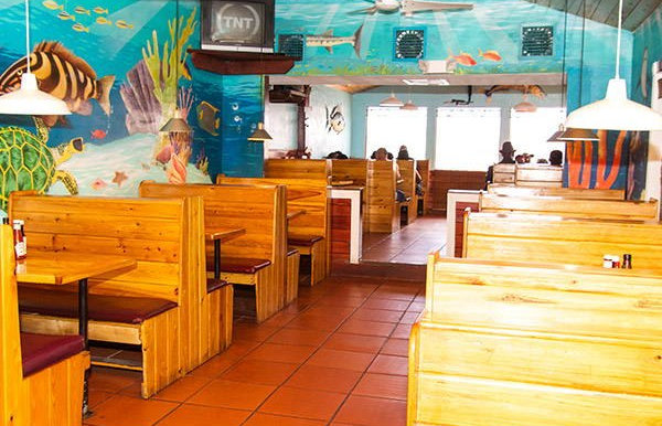 The old Twin Brothers dining room: wooden booths, terracotta floor, and the sea mural.