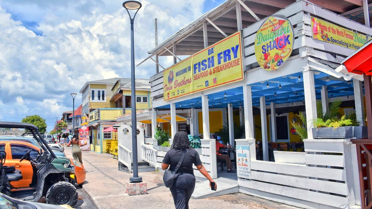 A guest walking up to Twin Brothers on the Fish Fry, under the welcome sign and the Daiquiri Shack.