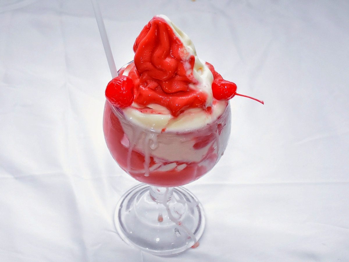 A Miami Vice daiquiri, strawberry and piña colada swirled together in a goblet with two cherries, at the Twin Brothers bar on Arawak Cay.
