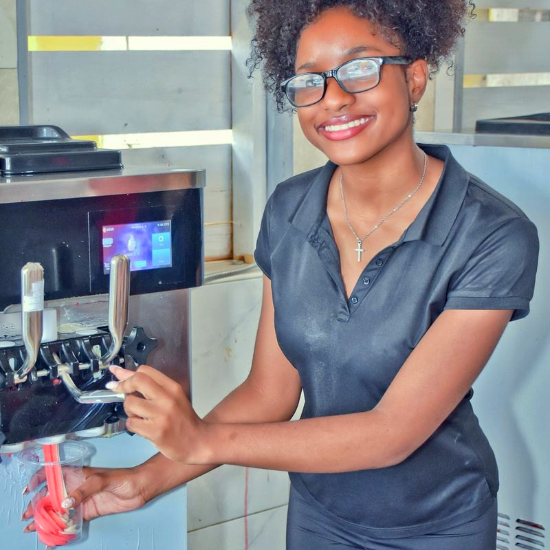 A Twin Brothers team member pulling a fresh strawberry daiquiri from the machine.