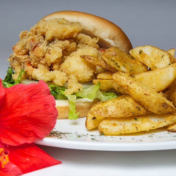 Fried cracked conch piled on a bun with thick-cut fries