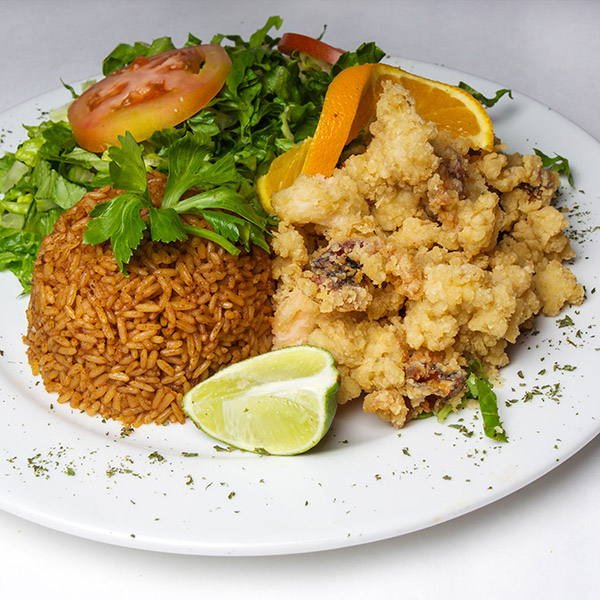 Cracked conch dinner with peas and rice, side salad and a lime wedge