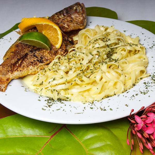 Whole grilled fish with fettuccine alfredo, orange and lime