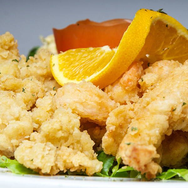 A golden fried seafood platter with orange and tomato